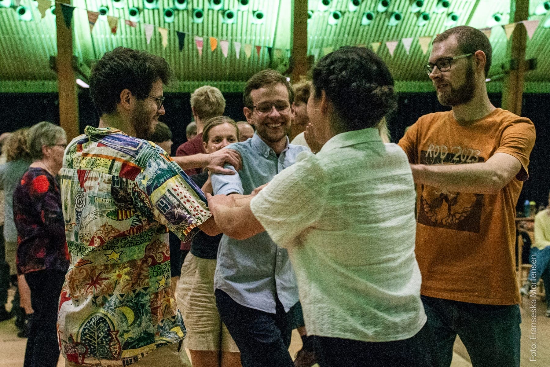 Festivalgæster danser sammen i en sal